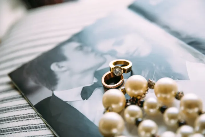 Ringe und Hochzeitsdetails mit Paarfoto