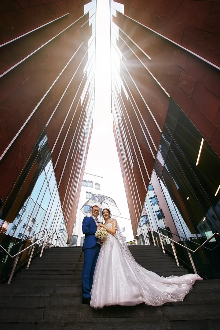 Brautpaarportrait in der HafenCity Hamburg auf einer Treppe zwischen moderner Architektur