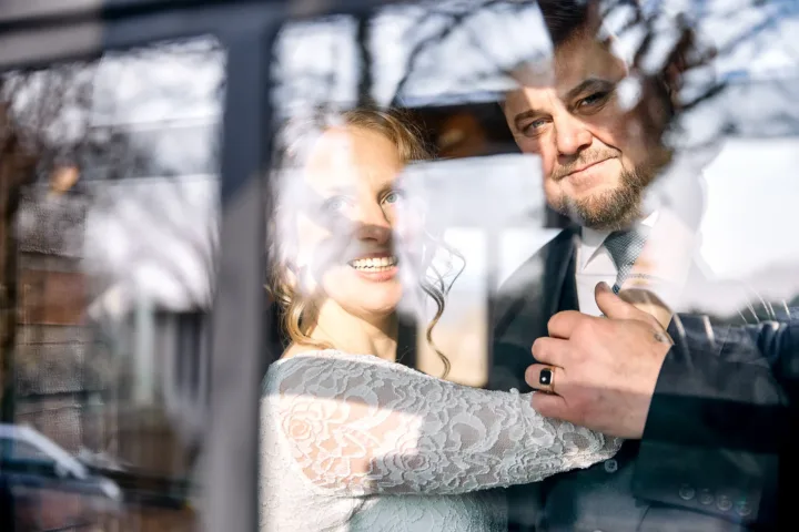 Brautpaarportrait am Fenster mit Reflexion